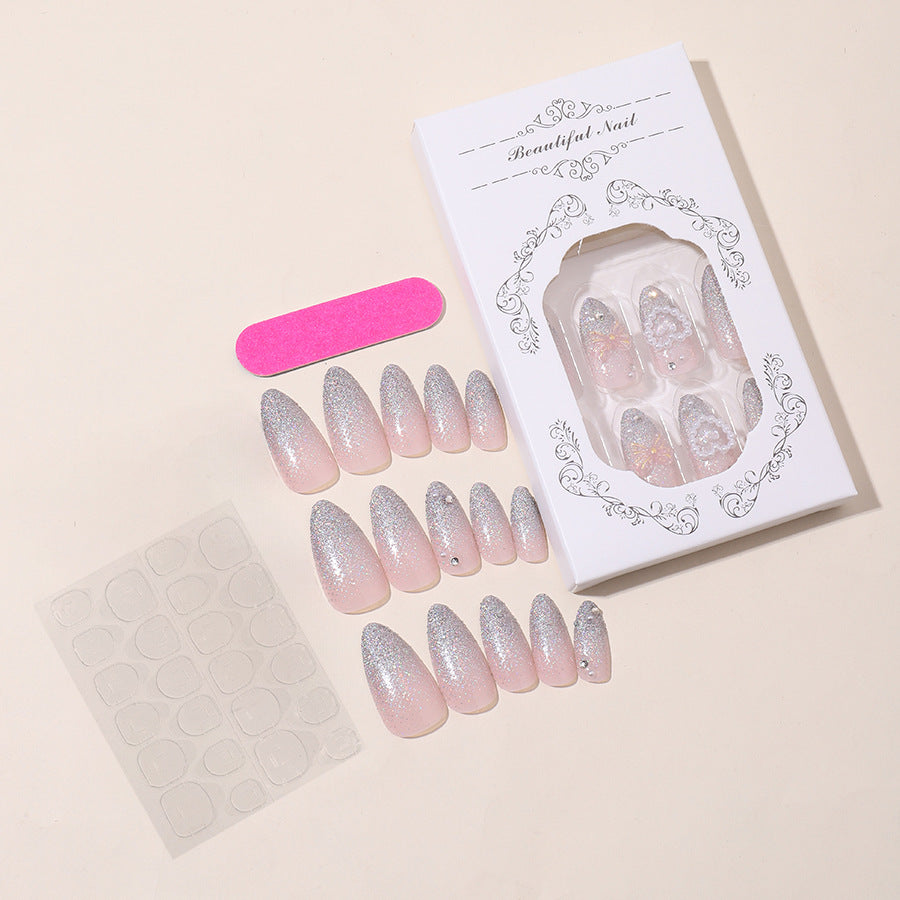 Almond nail polish with crystal bow and pearl heart decoration