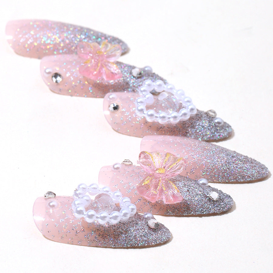 Almond nail polish with crystal bow and pearl heart decoration